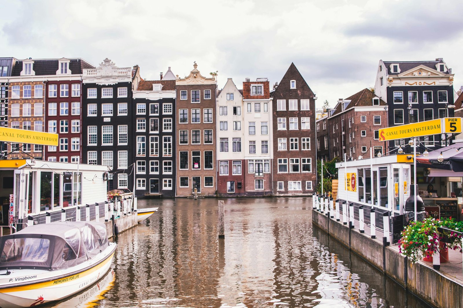 Explore Amsterdam's iconic canal view with historic homes and vibrant reflections.